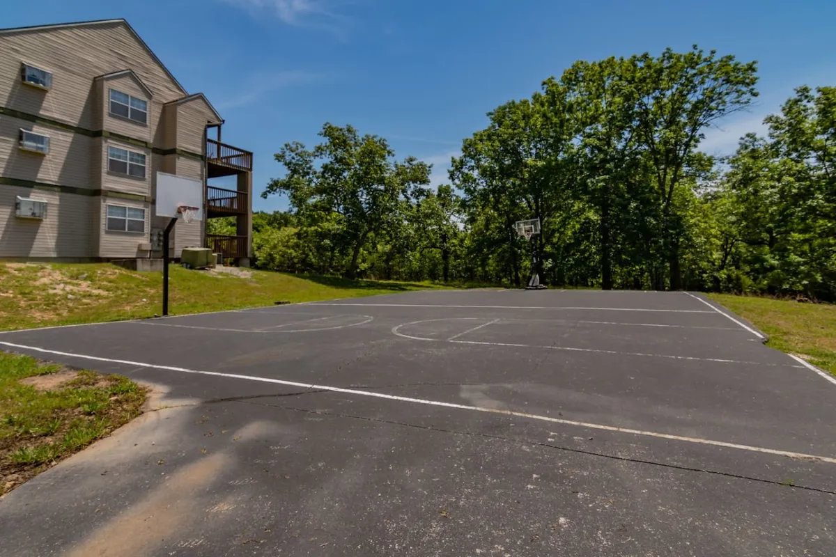 An active outdoor basketball court surrounded by greenery and resort buildings, inviting guests of all ages to enjoy friendly games and casual hangouts. The bright and energetic atmosphere suggests year-round activities and group fun.
